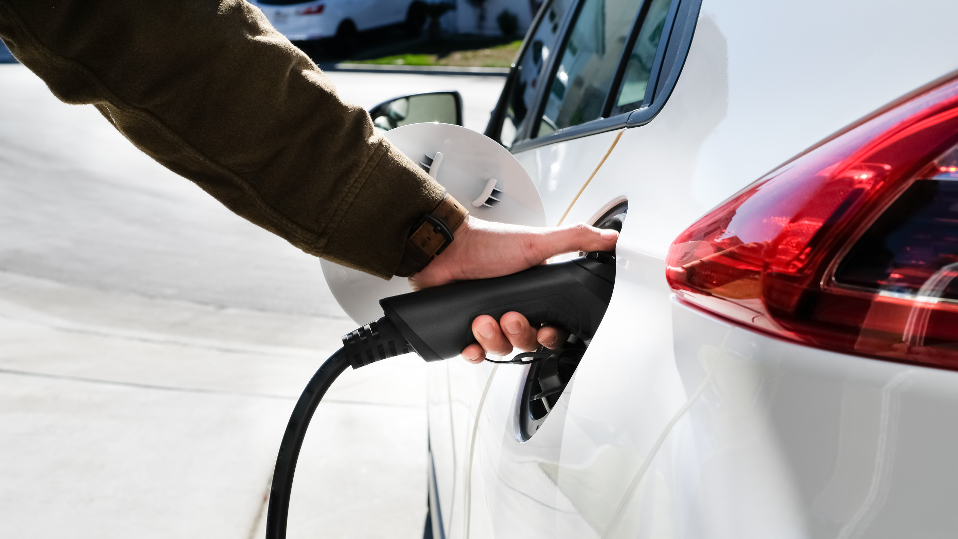 a person charging and electric vehicle